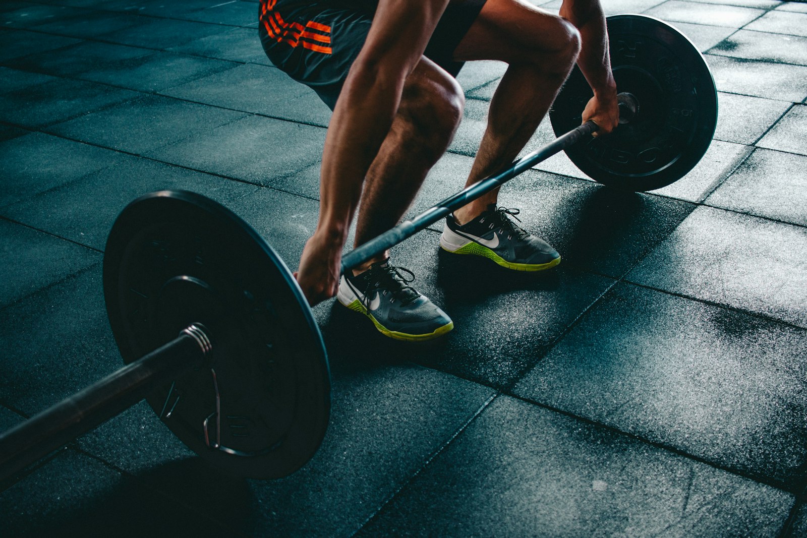 A lifter setting up over a loaded barbell on a gym floor