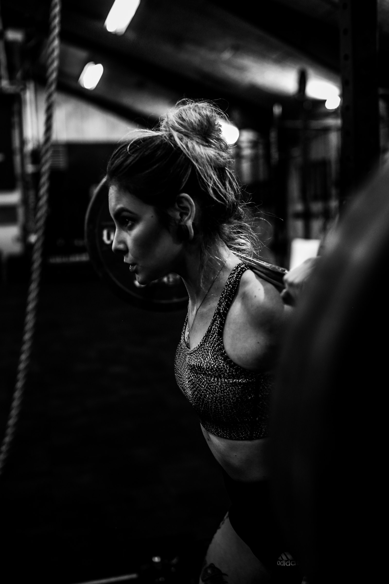 A lifter under a loaded barbell, photographed in black and white